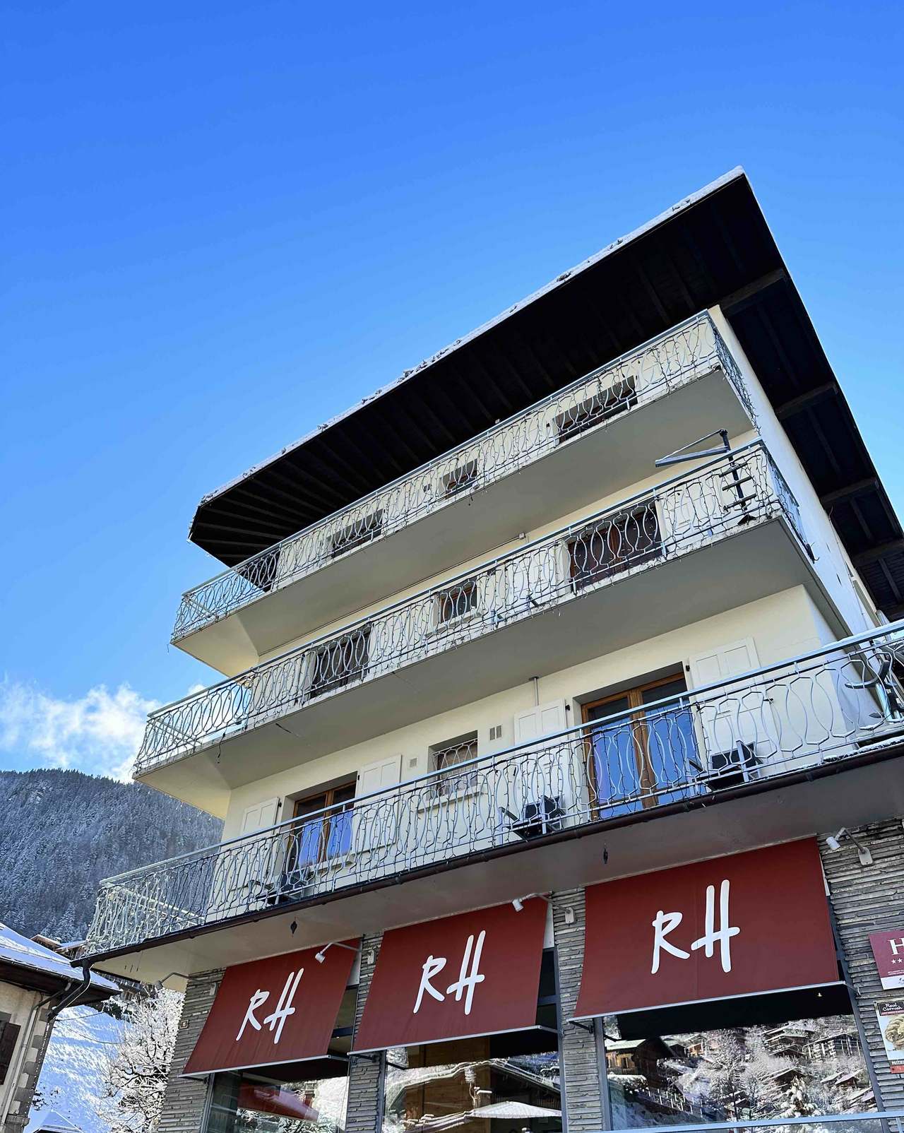 Les Rhodos in winter, snow on the roof and the red RH awnings