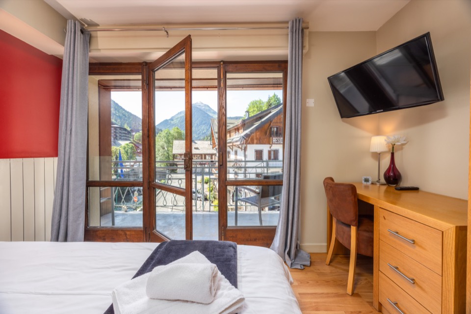 Room with the balcony doors open onto the mountains